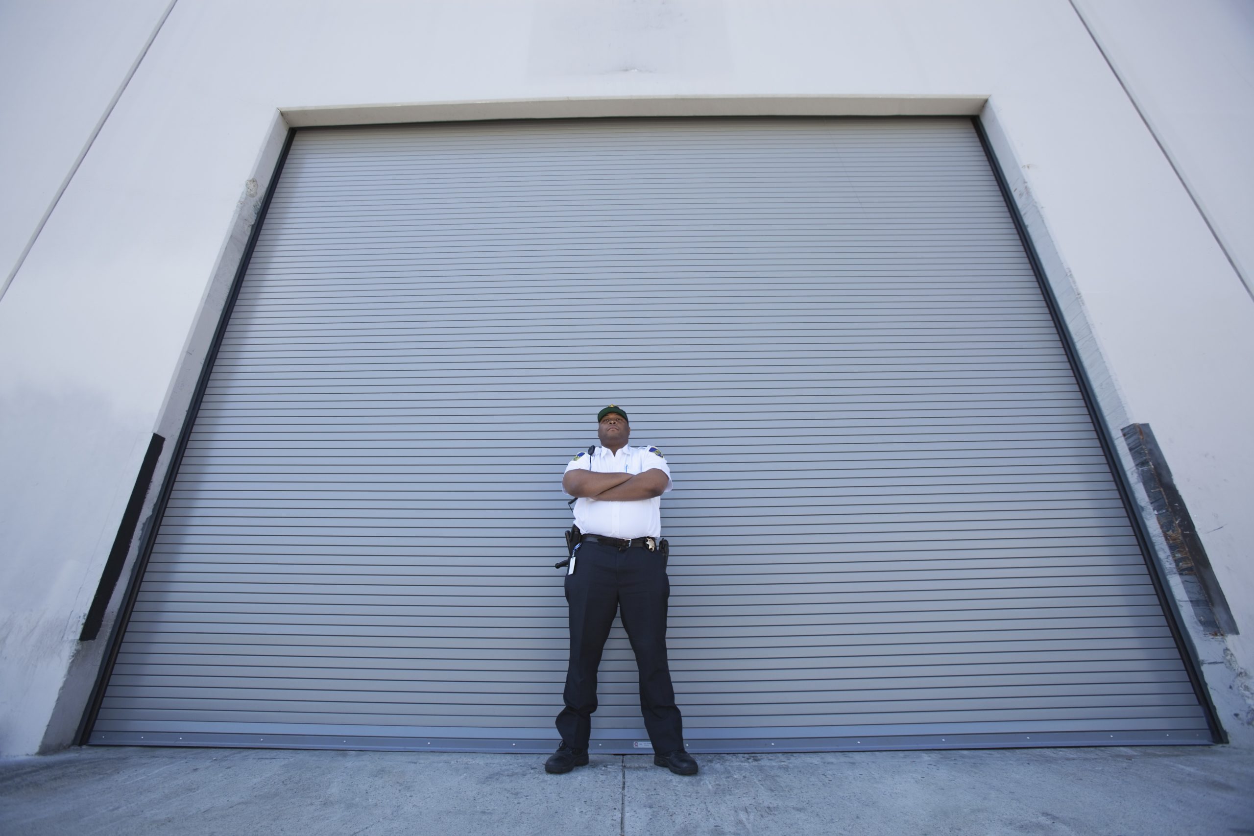 Перед закрытой. Warehouse Security Guard. Низкий угол. Closed Guard standing.